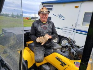 Un homme souriant sur un VTT tenant ses gants dans ses mains