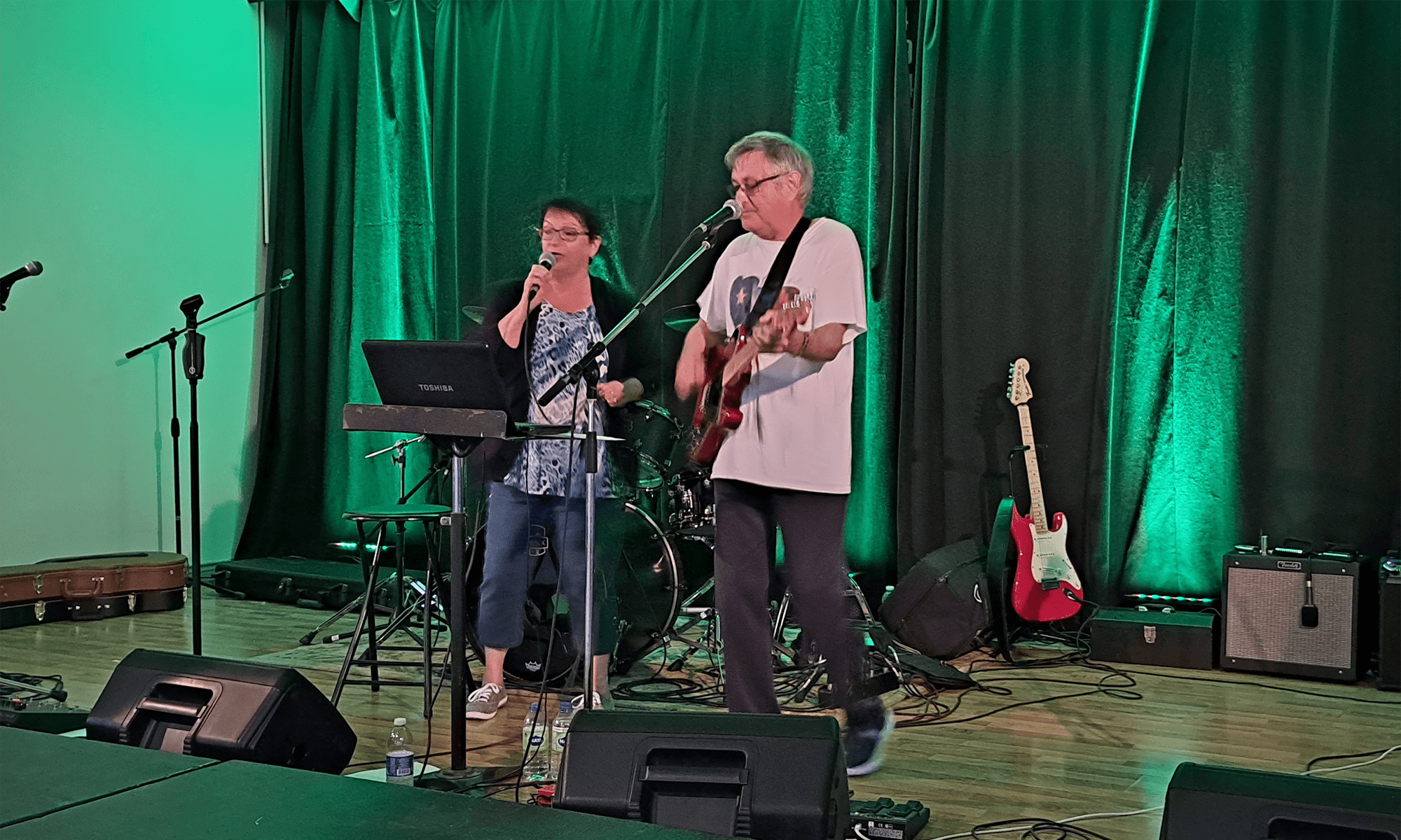 Un guitariste et une chanteuse en performance durant un concert.