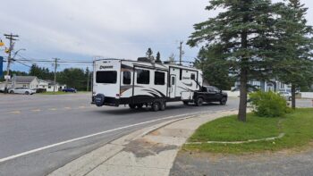 Camion trainant une longue roulotte dans un virage vers la droite sur une rue