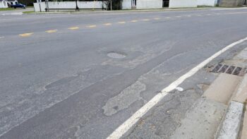 Une rue asphaltée endommagée avec quelques nids-de-poules