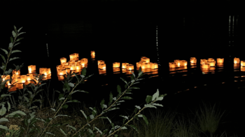 Lanternes lumineuse flottant sur l'eau en pleine nuit.