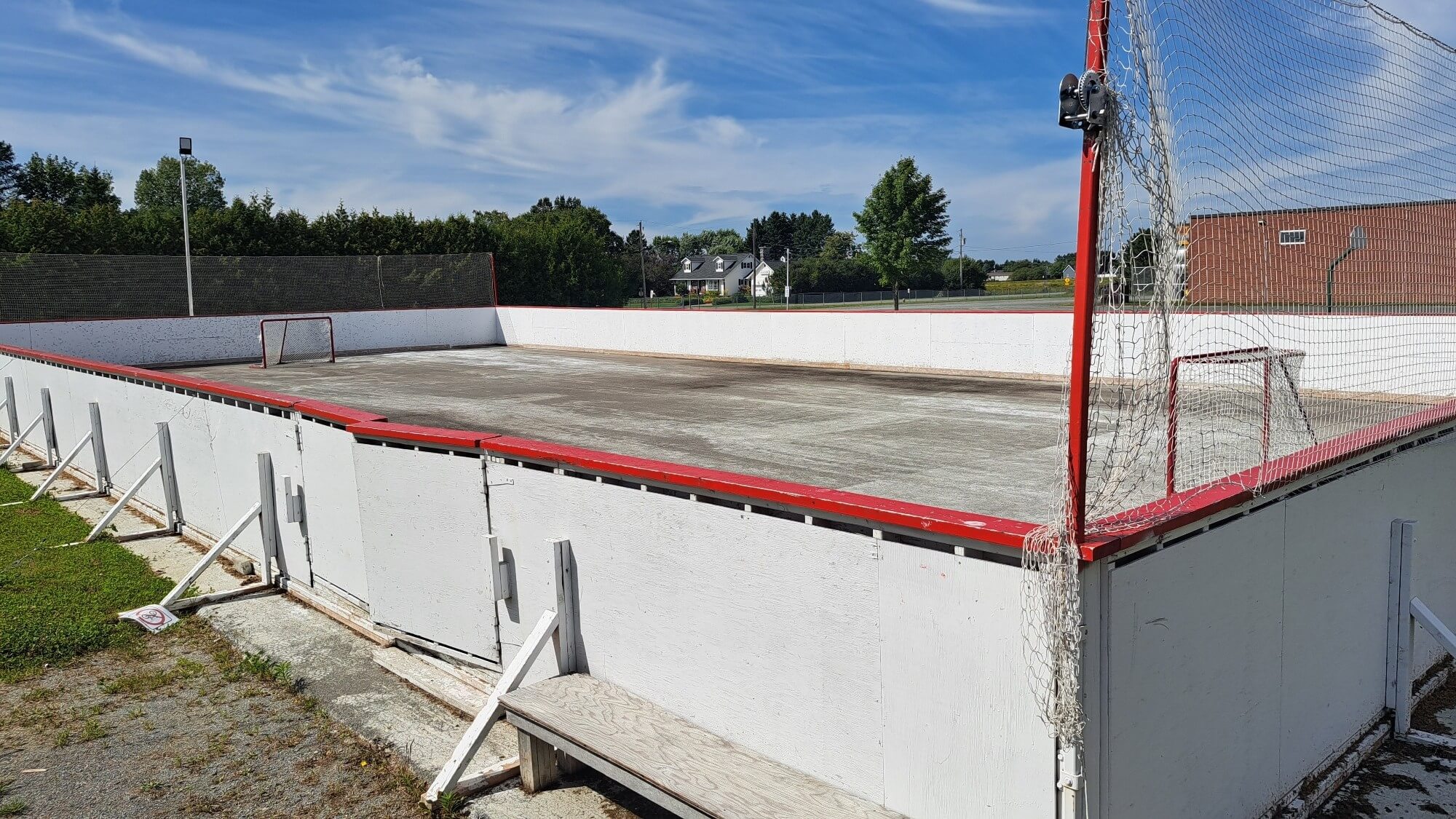 Patinoire extérieure avec la surface en ciment, lors d'une journée ensoleillé.