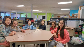 De jeunes élèves assises à une table.