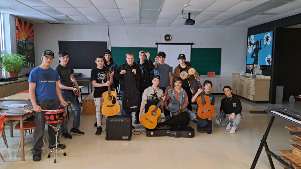 Des élèves dans une école tiennent en main des instruments de musique qu'ils ont reçu en dons.