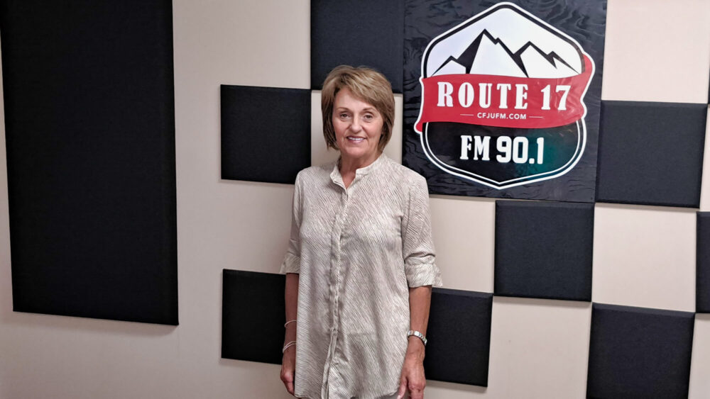 Femme portant une chemise blanche se tient debout dans le studio de la Radio des Hauts-Plateaux.