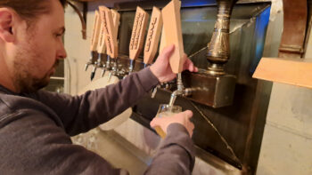 Un barman en train de faire couler une bière en fût.