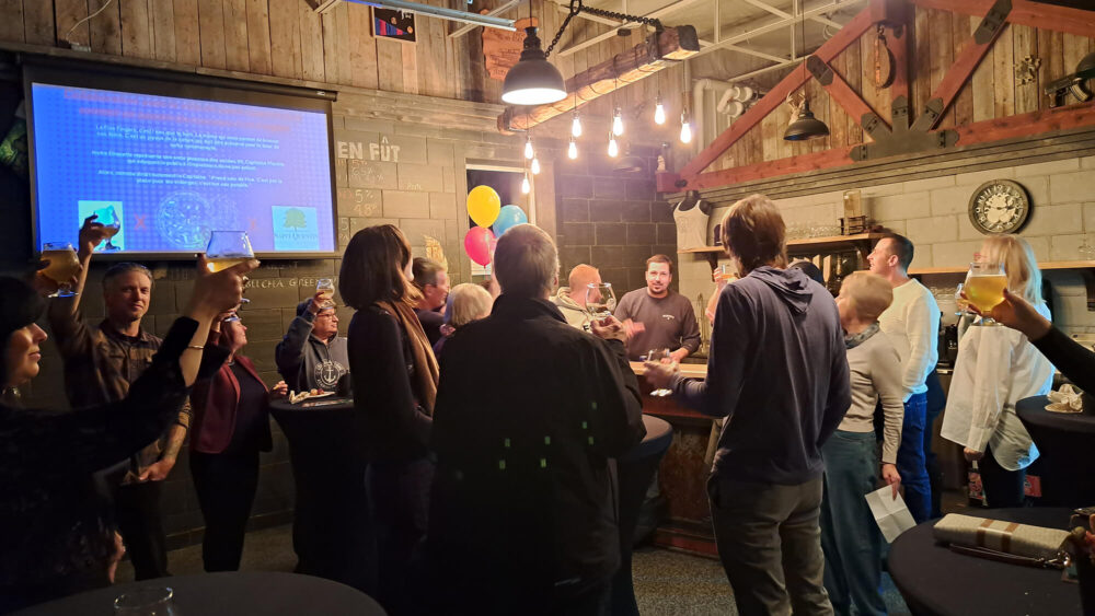 Un foule porte un toast à l'intérieur d'une microbrasserie.