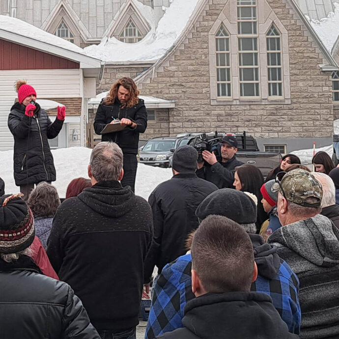 Trois personnes debout dans la boîte d'un camion s'adressent à une foule lors d'un rassemblement pacifique devant le bureau municipal de Saint-Quentin.