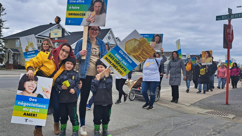 Une marche de manifestants, lors d'une journée de printemps grise et nuageuse.