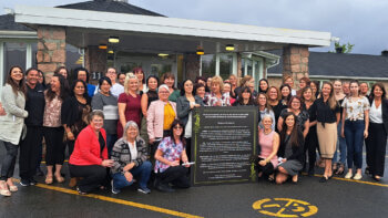 Les employés de la Résidence Mgr Melanson de Saint-Quentin, toutes des femmes, devant leur lieu de travail affichant le prix de reconnaissance offert par leurs employeurs.