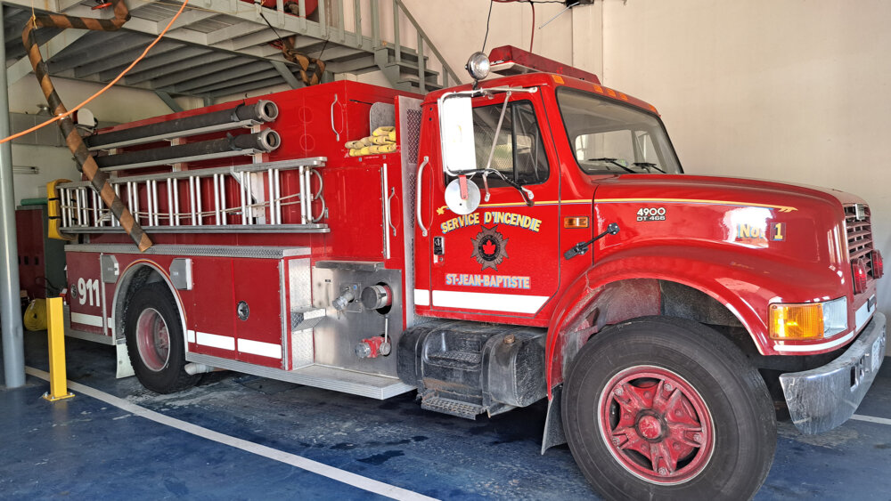 Camion de pompier rouge vue de côté à l'intérieur d'une caserne.