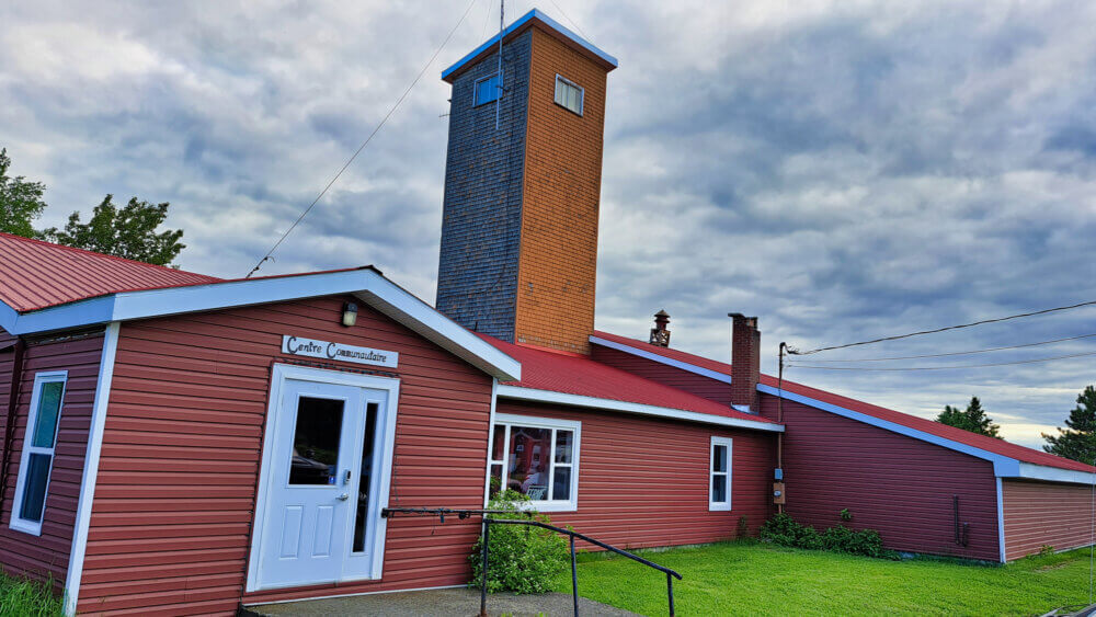 Centre communautaire de Saint-Jean-Baptiste-de-Restigouche. Le bâtiment est rouge est les portes sont blanches.