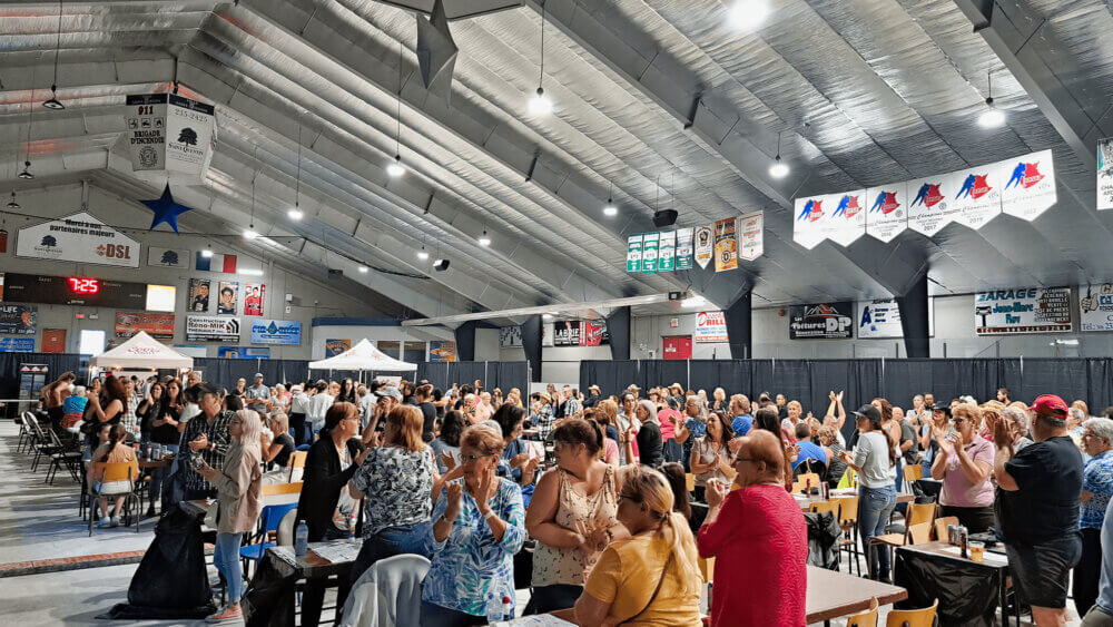 Une foule considérable est debout et applaudit, lors d'une soirée de bingo dans l'aréna de Saint-Quentin.