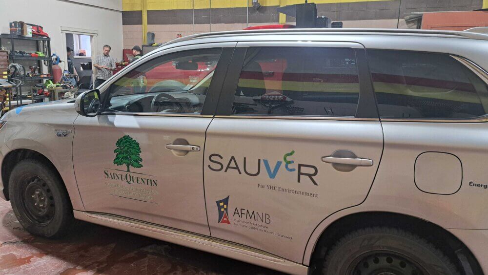 Une voiture hybride de couleur grise portant le logo de la Ville de Saint-Quentin et le l'AFMNB.